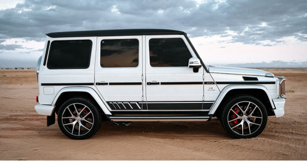 A black and white luxury SUV parked in a desert landscape